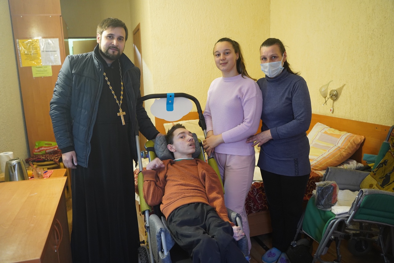 Руководитель социального отдела Волгодонской епархии иерей Алексий Скоробогатов передает инвалидную коляску для семьи беженцев, приобретенную на пожертвования верующих